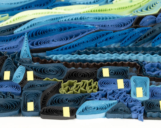 A quilled greeting card resembling Vincent van Gogh's painting 'Starry Night', featuring a vibrant night sky with stars and a village.