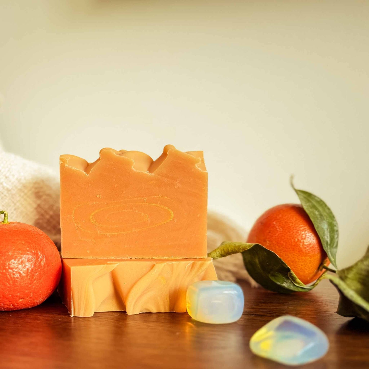 Bar of soap with oranges and a leaf on a wooden surface