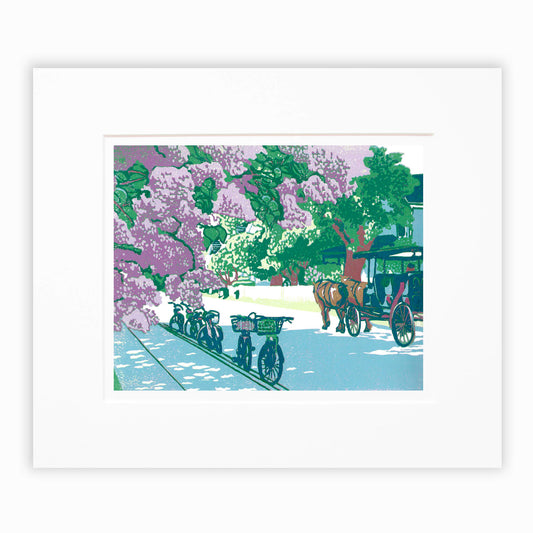 Lilac Avenue is a nine-color 10" x 8" block print with gold embellishments showcasing a dreamy street on Mackinac Island during the Lilac Festival with the wonderfully-smelling lilac bushes are in full bloom. Matted in white.