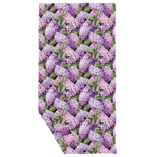 A multicolored microfiber dish towel with a waffle texture featuring a pattern of purple lilacs.