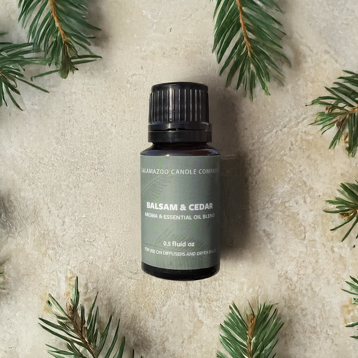 A .5 fluid oz. bottle of 'Balsam & Cedar' aroma & essential oil by Kalamazoo Candle Company.