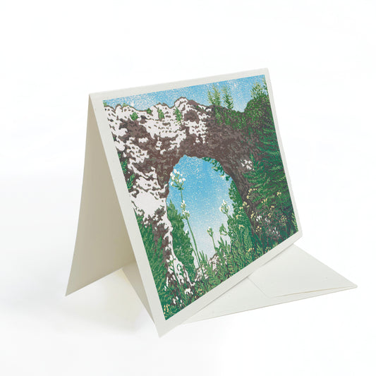 A blank A6 greeting card featuring a block print of Mackinac Island's Arch Rock.