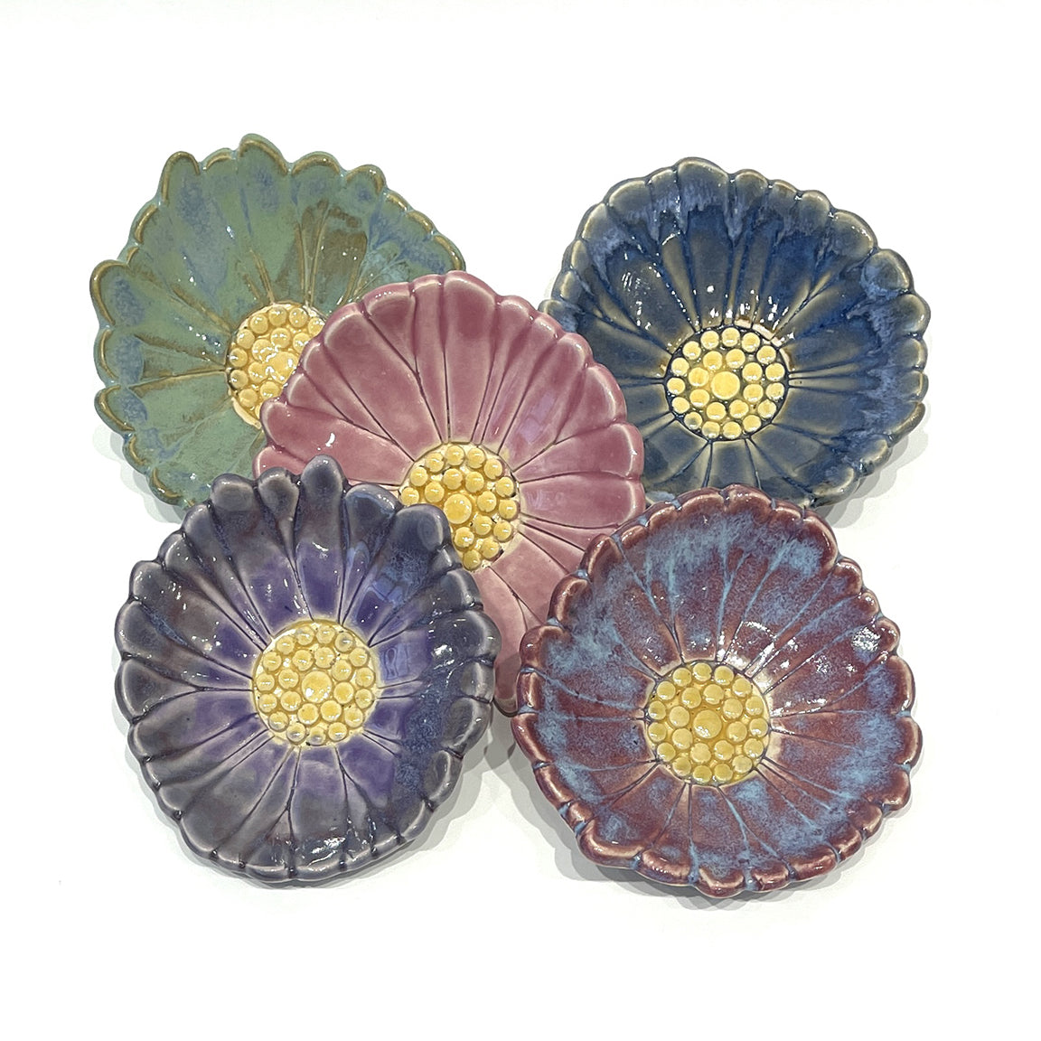 A handmade ceramic dish by Michigan artist Jeanne DeHaan. Perfect for holding tea bags, earrings, or small items. 3 inches wide.