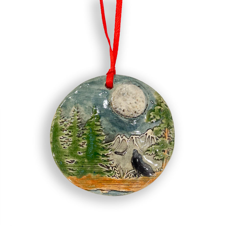 Add a touch of nature to your Christmas tree with these handmade in Michigan ceramic ornaments, featuring nature scenes with a wolf howling at the moon by Jeanne DeHaan.