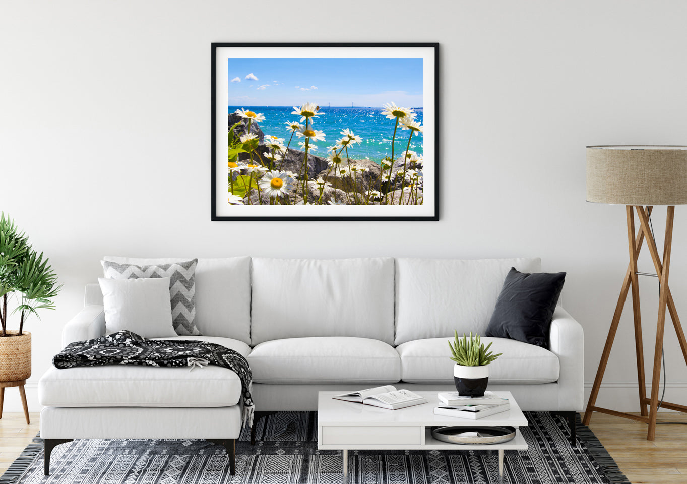 Daisies happily sway in the breeze along the shoreline of Mackinac Island with the Mackinac Bridge on the horizon. Photo by Jennifer Wohletz of Mackinac Memories.