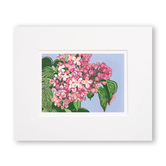 "Lilacs" is a 7"x5" seven-color reduction block print by Natalia Wohletz of pink lilacs with vibrant green leaves blooming against a periwinkle sky. Inspired by Mackinac Island lilacs.