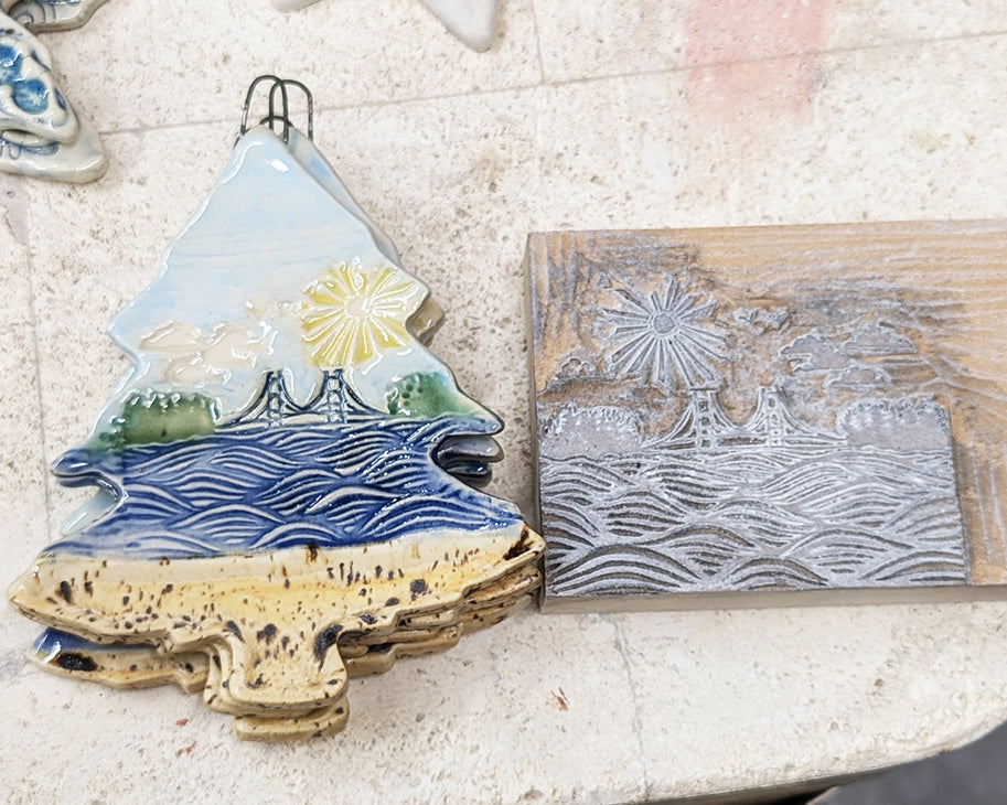 3" ceramic tree ornament featuring the Mackinac Bridge spanning the Great Lakes on a sunny day. Collaboration between Michigan artists Jeanne DeHaan and Natalia Wohletz.