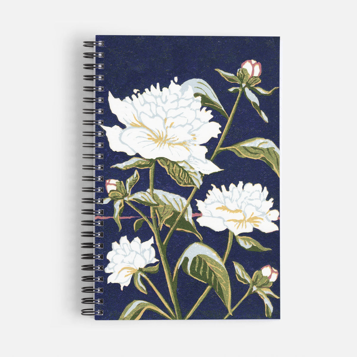A spiral-bound notebook with a dark navy blue cover featuring a botanical illustration of white peonies with green leaves and buds, shown on a light gray background by Natalia Wohletz of Peninsula Prints.