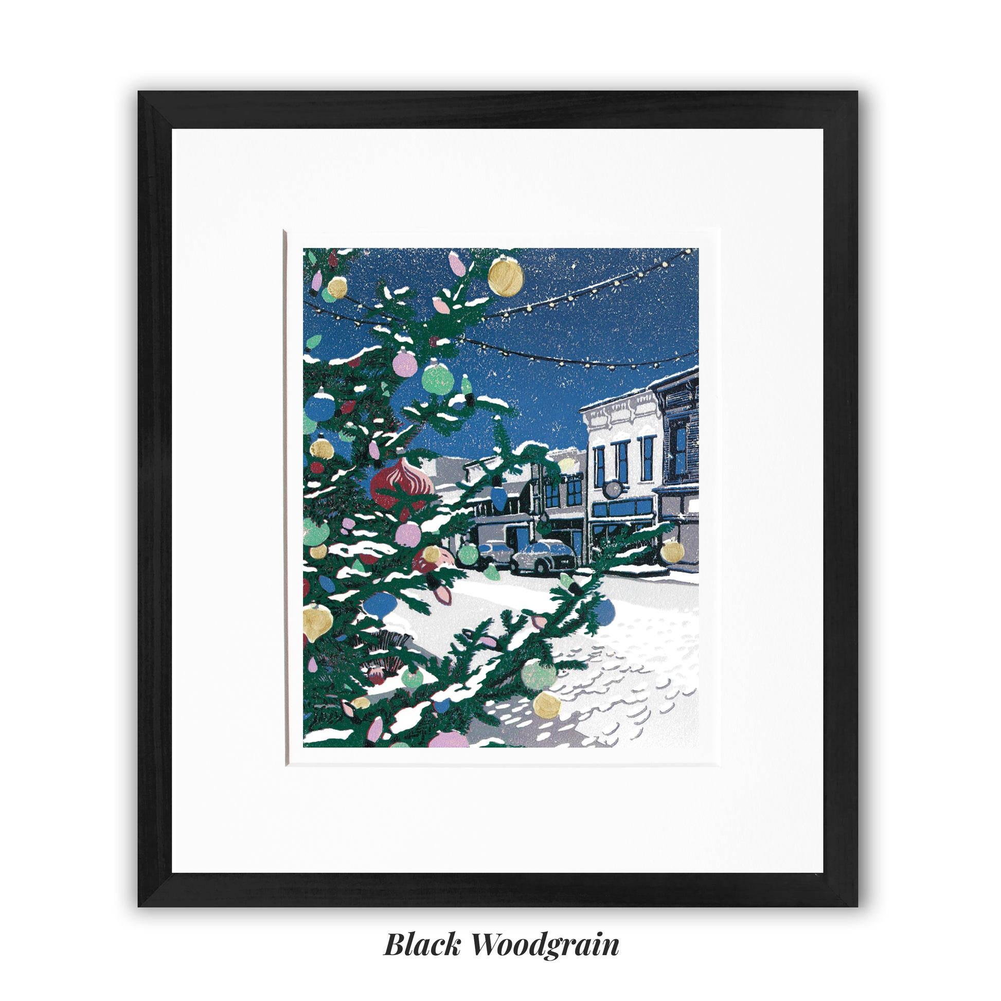 "Small Town Christmas" block print by Peninsula Prints featuring a community Christmas tree and small town street, framed in a narrow black woodgrain frame.