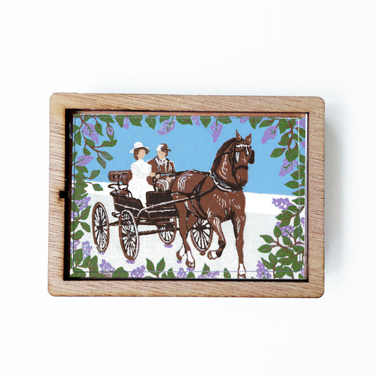 Decorative magnet featuring the block print, "Somewhere in Time Carriage Ride," by Peninsula Prints. The magnet has a protective clear coating and wooden frame.