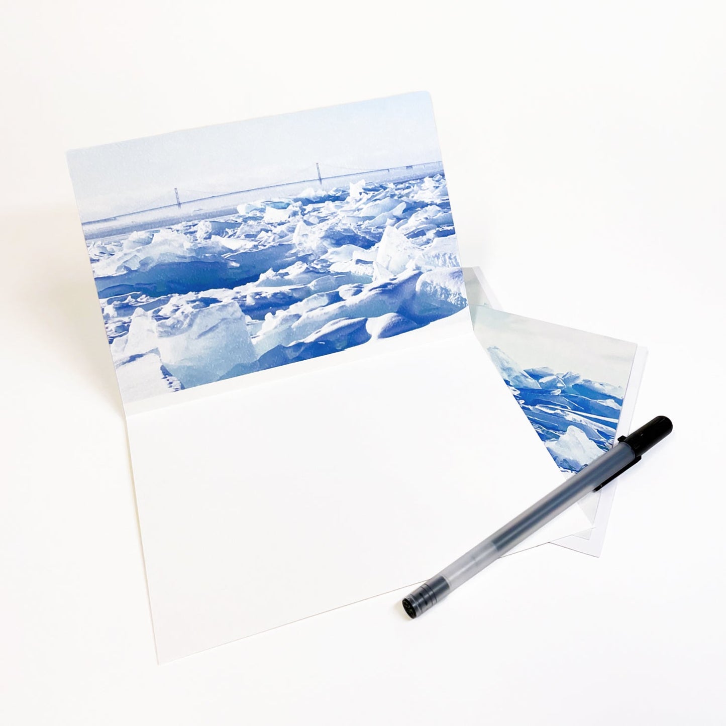Blank greeting card featuring a photograph featuring a view of the Mackinac Bridge behind a wall of blue ice by local artist Jennifer Wohletz of Mackinac Memories. 